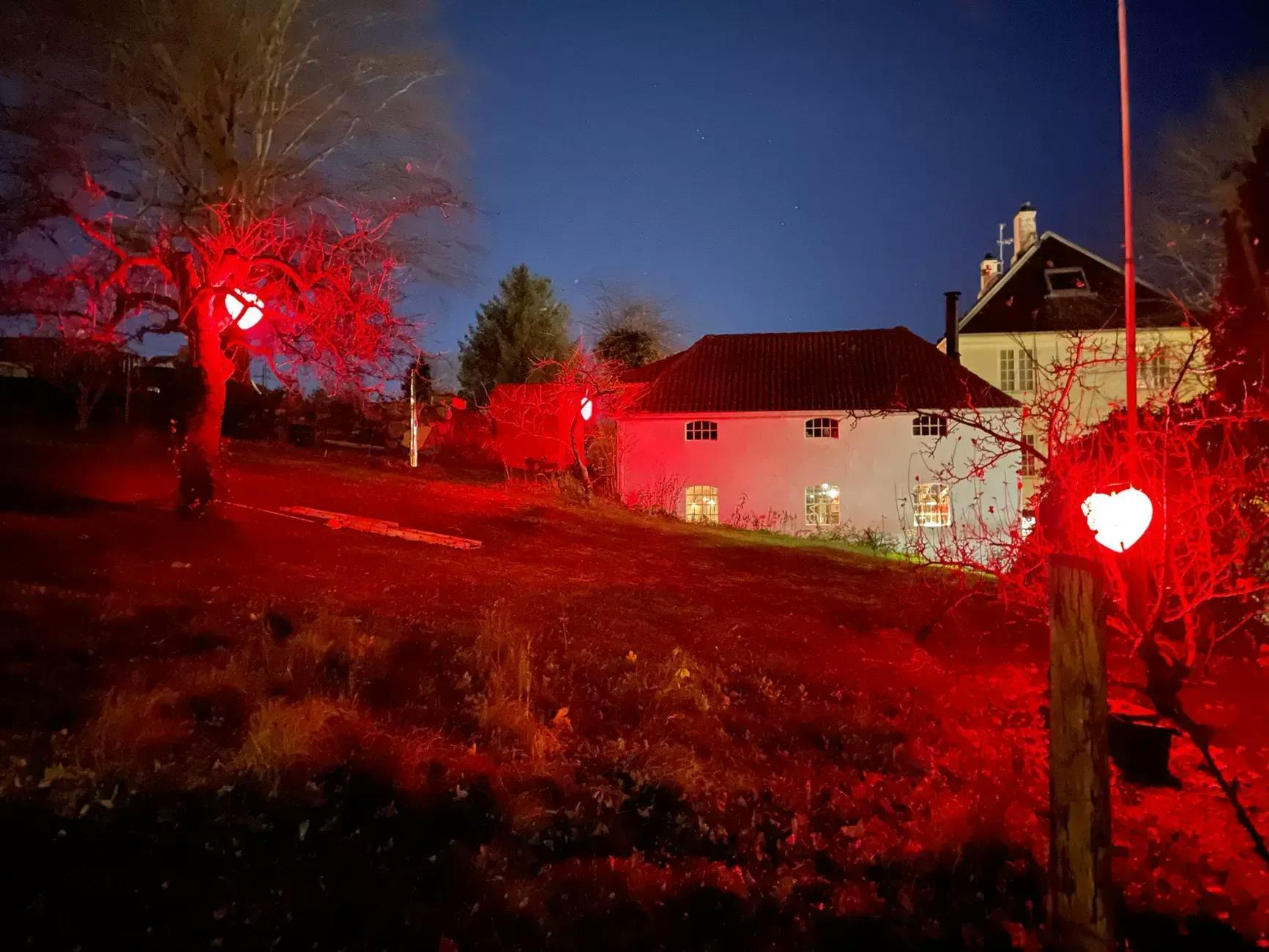 Hagen i Strandgata 76 på kvelden lyst opp av røde hjertelys